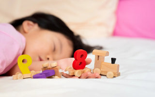 Slapend kind met educatief speelgoed – slaap bevordert leerontwikkeling en geheugen na spelen.